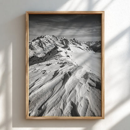 Photographic wall decor of black and white wind sculpted snow ridge with alpine mountains and textured snow