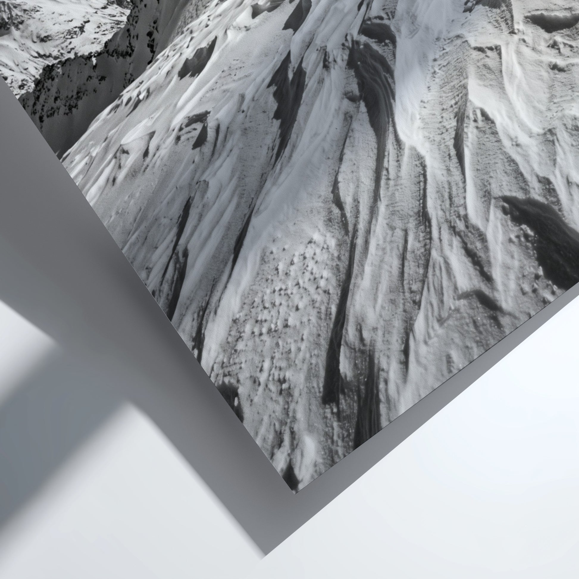 Photographic wall decor of black and white wind sculpted snow ridge with alpine mountains and textured snow