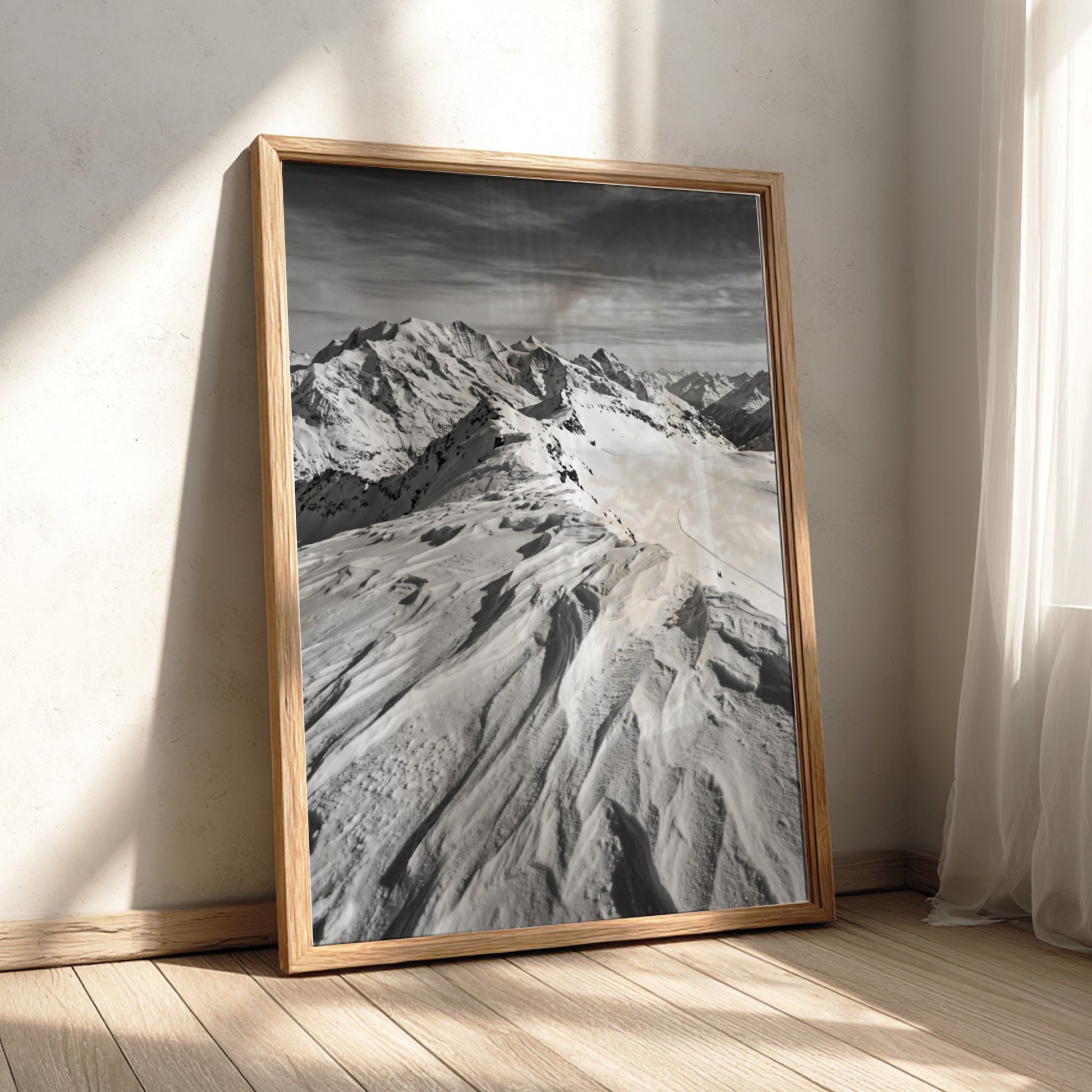 Photographic wall decor of black and white wind sculpted snow ridge with alpine mountains and textured snow