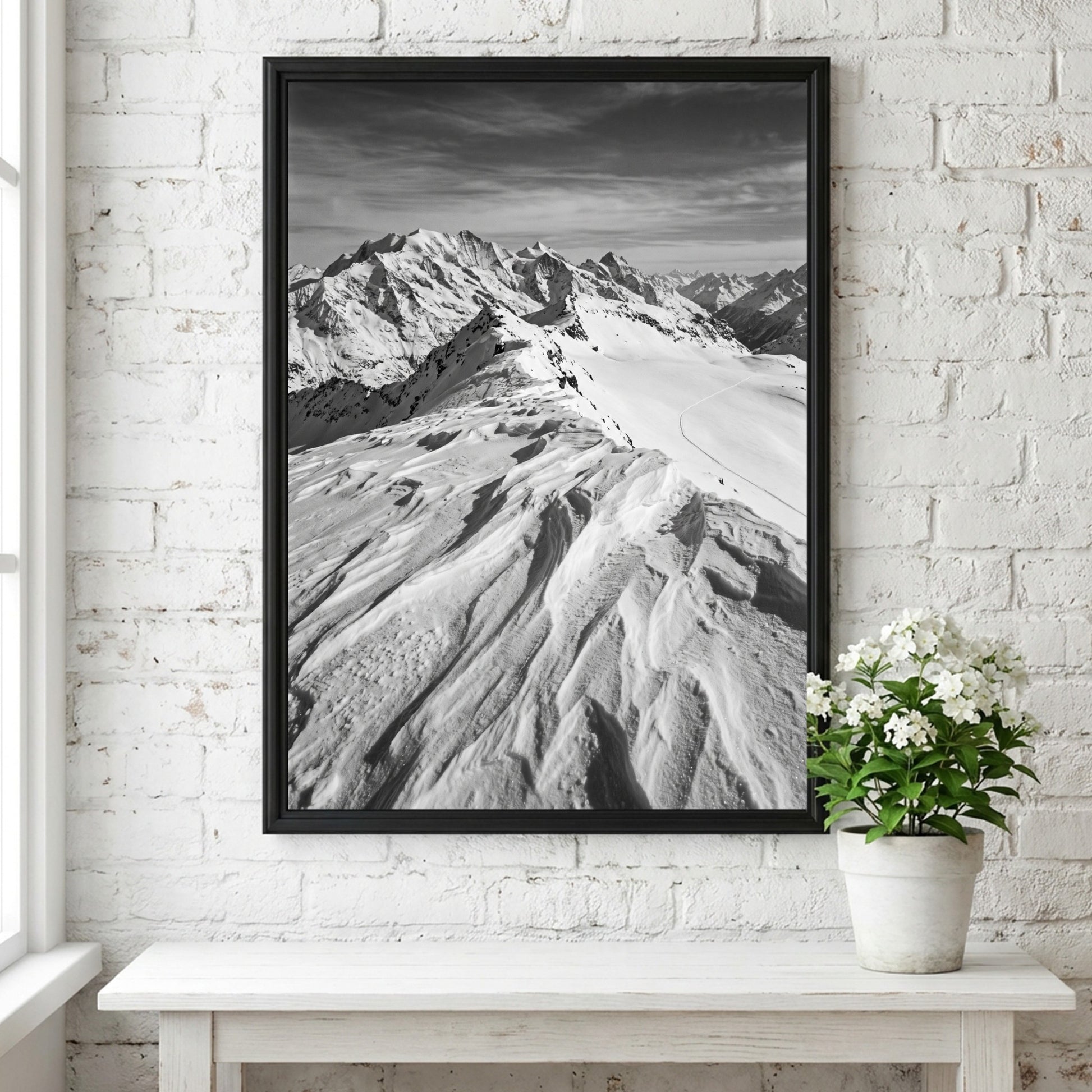 Photographic wall decor of black and white wind sculpted snow ridge with alpine mountains and textured snow