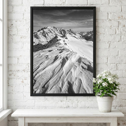 Photographic wall decor of black and white wind sculpted snow ridge with alpine mountains and textured snow