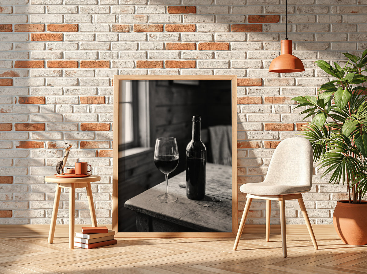 Wall decor poster showing black and white wine bottle and glass on rustic wooden table with soft window light