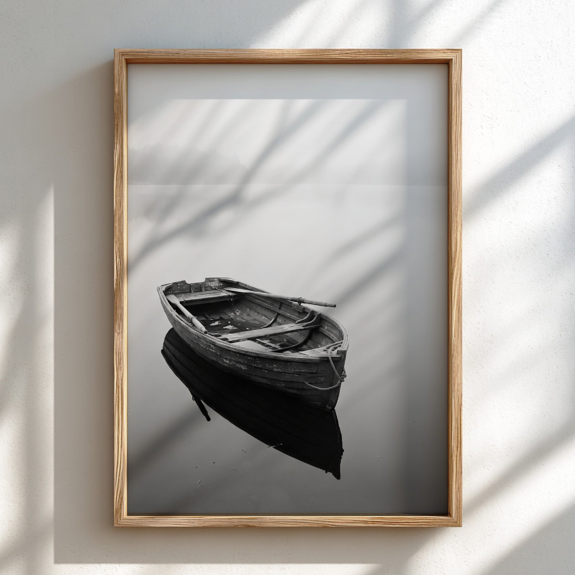 Black and white wall decor featuring a wooden rowing boat floating on calm water with soft reflections
