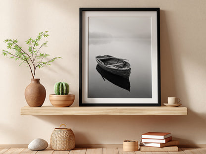 Black and white wall decor featuring a wooden rowing boat floating on calm water with soft reflections
